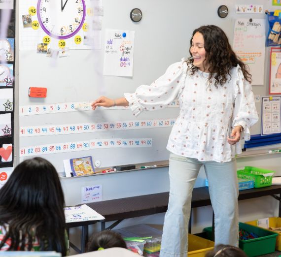 웨슬리 샌츠가 곤자가 대학 험딩슨 센터에서 국제기와 함께 학생들과 서 있다.